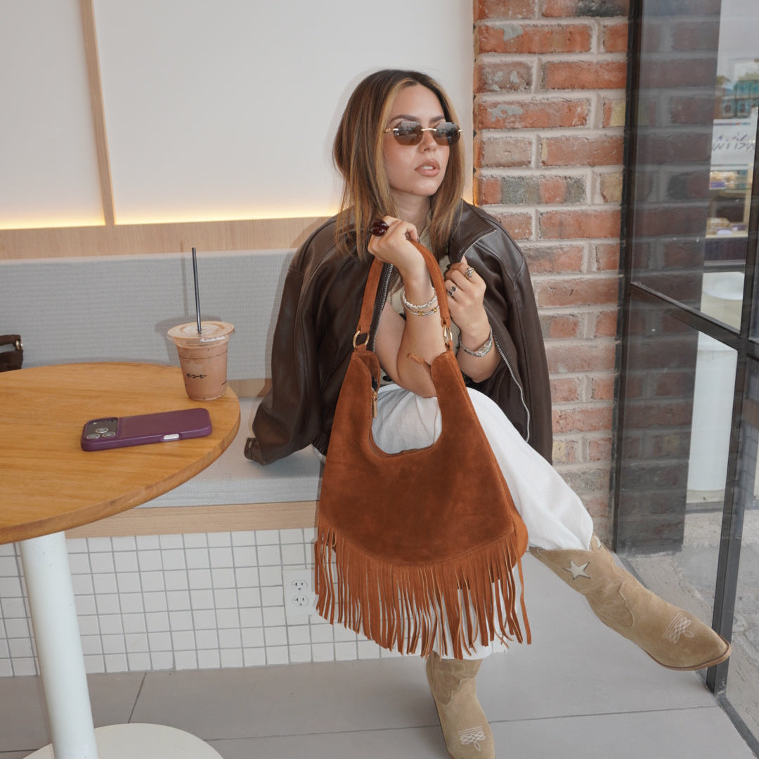 Zaza Bag es Confeccionada artesanalmente en León, Guanajuato, 100% piel con textura de gamuza y un diseño de flecos que aporta dinamismo y elegancia bohemia. Su diseño espacioso incluye compartimentos internos para un orden impecable y una correa perfecta para llevar al hombro con total comodidad.

Especificaciones del producto:

Material exterior: 100% piel vacuna (acabado en gamuza)

Detalles: Flecos frontales de piel y herrajes metálicos

Interior: Amplio compartimento principal con bolsillos internos de